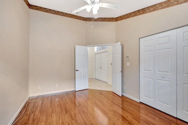 2445 Stonegate Dr, Wellington, FL 33414 - unfurnished bedroom featuring a closet, baseboards, light wood-type flooring, and a ceiling fan