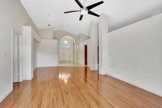 2445 Stonegate Dr, Wellington, FL 33414 - unfurnished living room featuring baseboards, a ceiling fan, light wood-style floors, high vaulted ceiling, and arched walkways