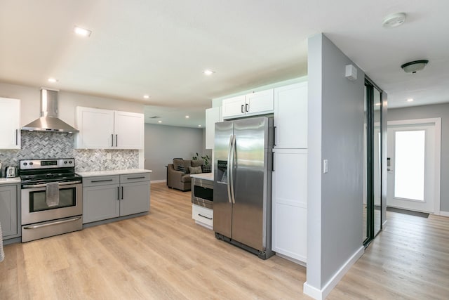 8421 NW 24th St, Sunrise, FL 33322 - kitchen with light wood-style floors, light countertops, wall chimney exhaust hood, stainless steel appliances, and decorative backsplash