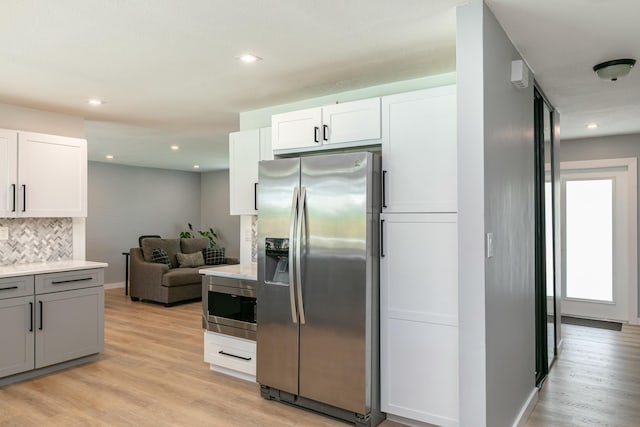 8421 NW 24th St, Sunrise, FL 33322 - kitchen featuring light countertops, light wood-style flooring, backsplash, and stainless steel appliances