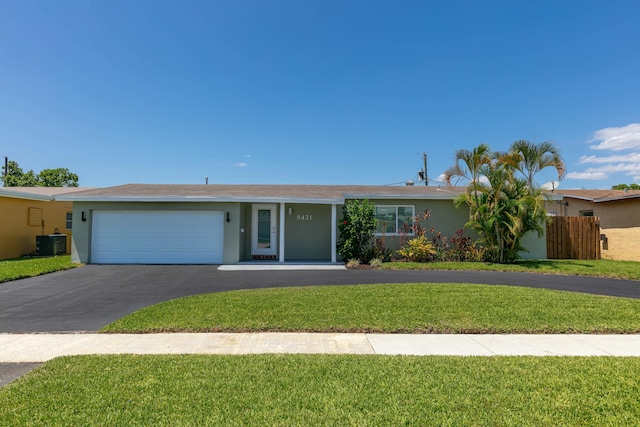 8421 NW 24th St, Sunrise, FL 33322 - ranch-style house featuring a garage, stucco siding, a front yard, central air condition unit, and driveway