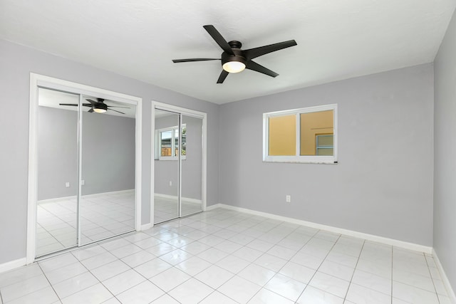 8421 NW 24th St, Sunrise, FL 33322 - unfurnished bedroom featuring two closets, light tile patterned flooring, baseboards, and ceiling fan