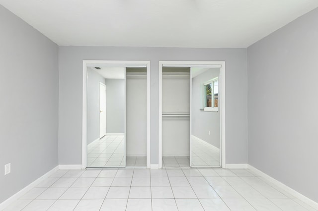 8421 NW 24th St, Sunrise, FL 33322 - unfurnished bedroom with baseboards, two closets, and light tile patterned flooring