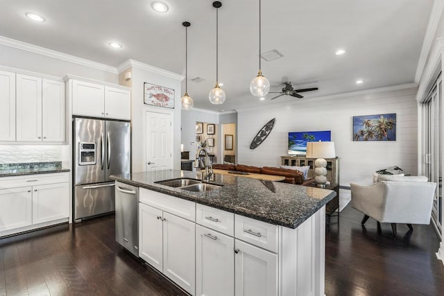 1345 Bourne Dr, Jupiter, FL 33458 - kitchen featuring a sink, open floor plan, ornamental molding, dark stone counters, and stainless steel appliances