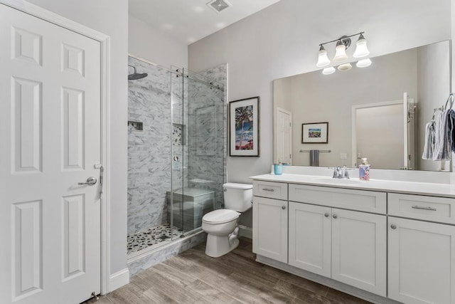 1345 Bourne Dr, Jupiter, FL 33458 - bathroom with vanity, toilet, a shower stall, visible vents, and wood finished floors
