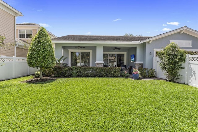 1345 Bourne Dr, Jupiter, FL 33458 - exterior space featuring a front lawn, a ceiling fan, stucco siding, and fence