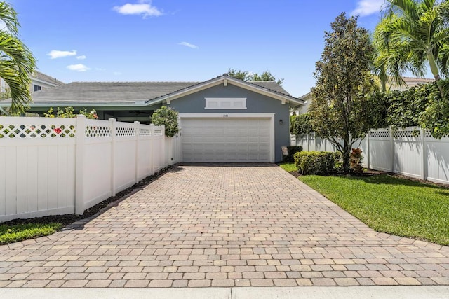 1345 Bourne Dr, Jupiter, FL 33458 - garage featuring fence and decorative driveway