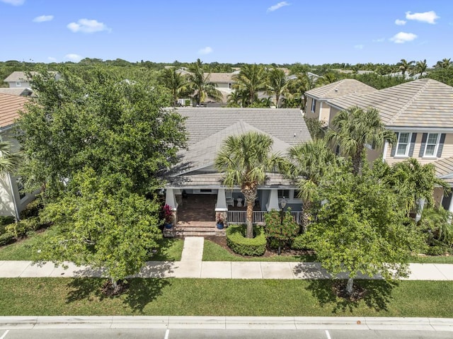 1345 Bourne Dr, Jupiter, FL 33458 - view of front of house featuring a tile roof, covered porch, and a front lawn