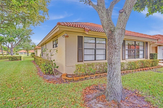 4655 Mahoe Tree Pl Unit A, Boynton Beach, FL 33436 - view of side of home with a tile roof, stucco siding, and a yard