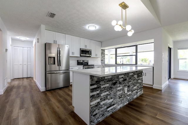 2381 SE Aneci St, Port Saint Lucie, FL 34984 - kitchen featuring stainless steel appliances, dark wood-type flooring, light countertops, white cabinetry, and a textured ceiling