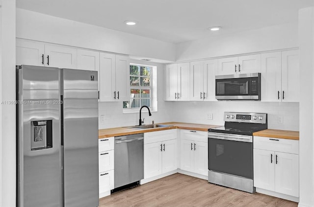 kitchen featuring light wood-style floors, wooden counters, a sink, and stainless steel appliances