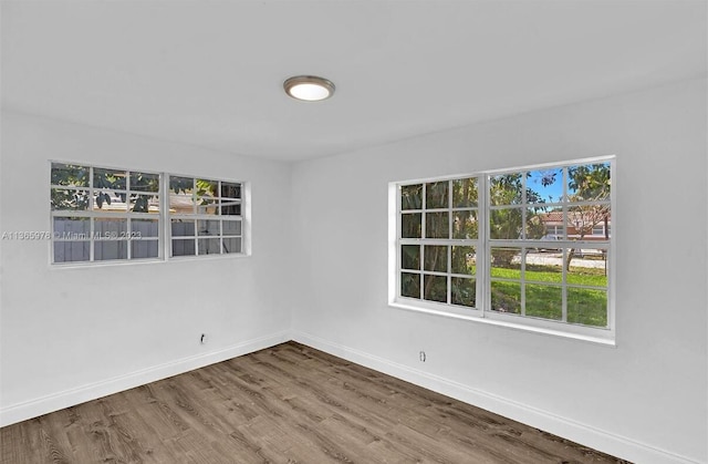 empty room with baseboards and wood finished floors