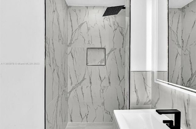 bathroom with a marble finish shower and vanity
