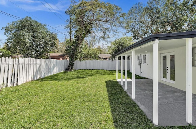 view of yard featuring french doors, a fenced backyard, and a patio area