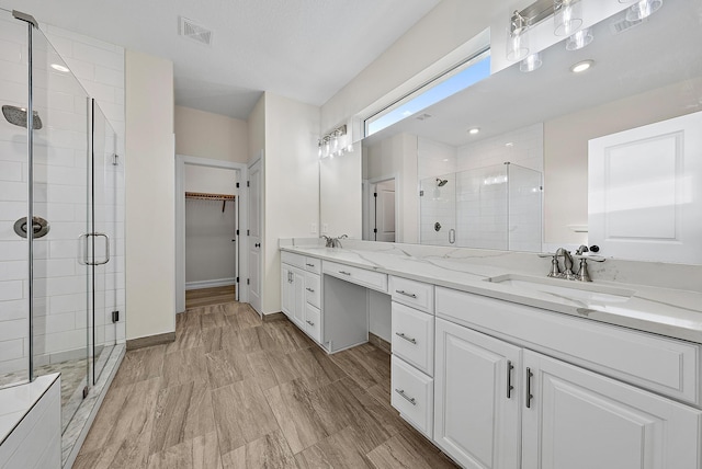 4770 SW Ardsley Dr, Stuart, FL 34997 - bathroom with double vanity, a shower stall, a spacious closet, and baseboards