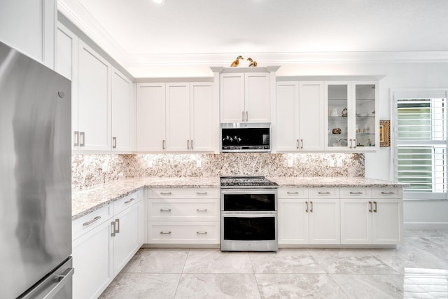 kitchen with glass insert cabinets, white cabinets, ornamental molding, appliances with stainless steel finishes, and decorative backsplash