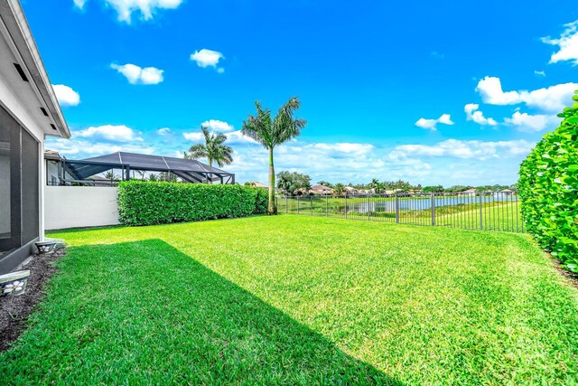 view of yard with a fenced backyard and a water view