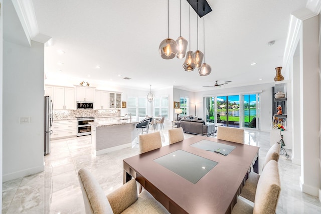 dining area featuring crown molding, ceiling fan with notable chandelier, recessed lighting, marble finish floor, and baseboards