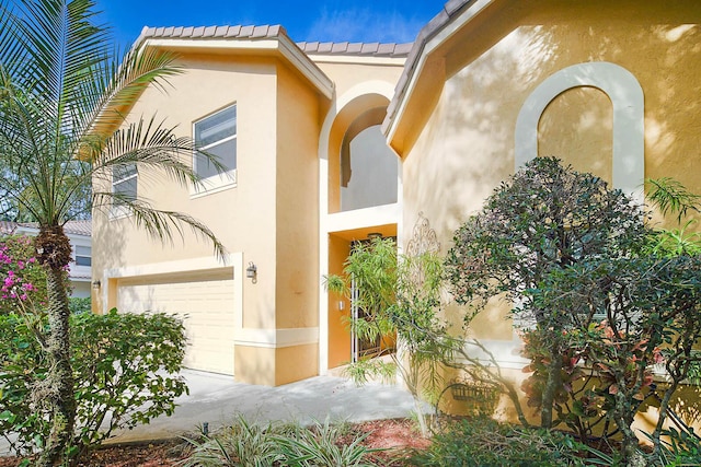 exterior space with a garage and stucco siding
