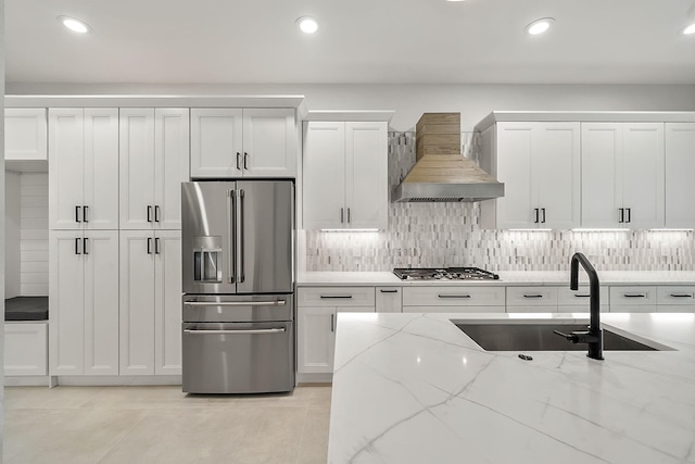 kitchen featuring recessed lighting, a sink, wall chimney exhaust hood, backsplash, and appliances with stainless steel finishes