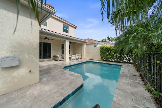 view of swimming pool with an outdoor living space, a fenced backyard, a ceiling fan, and a fenced in pool