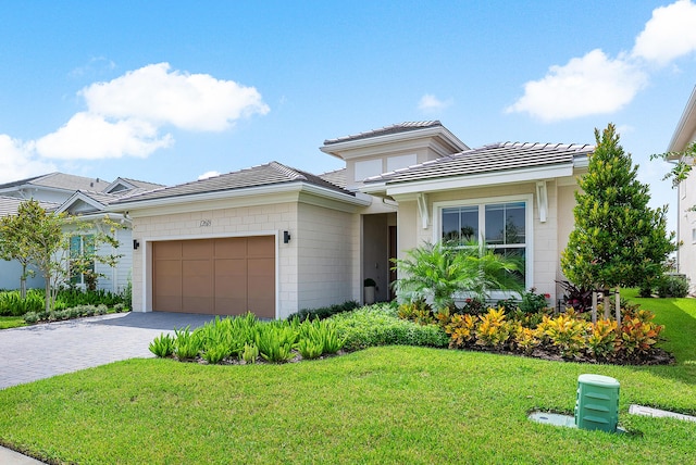 12618 Nautilus Cir, Palm Beach Gardens, FL 33412 - view of front of house with a garage, a front yard, concrete block siding, and decorative driveway