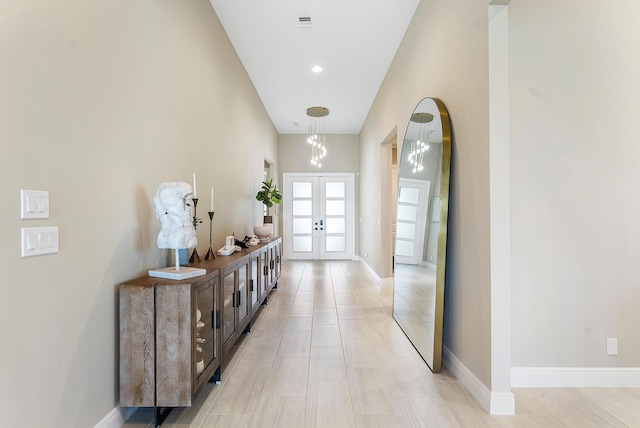 12618 Nautilus Cir, Palm Beach Gardens, FL 33412 - hallway featuring french doors, baseboards, and an inviting chandelier