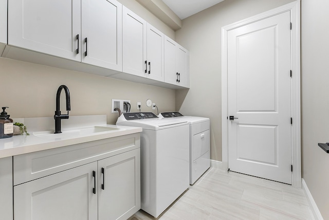 12618 Nautilus Cir, Palm Beach Gardens, FL 33412 - washroom with baseboards, separate washer and dryer, a sink, and cabinet space