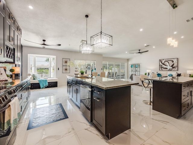 8540 Lake Cypress Rd, Lake Worth, FL 33467 - kitchen with ceiling fan with notable chandelier, stone countertops, marble finish floor, a sink, and a center island with sink