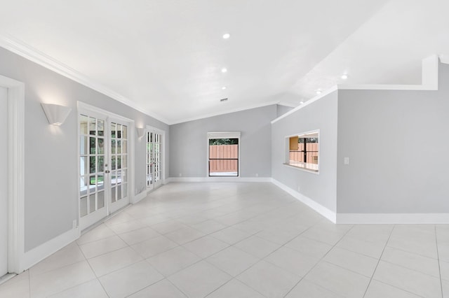 empty room with crown molding, light tile patterned floors, baseboards, and lofted ceiling