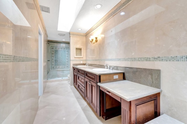 bathroom featuring a shower stall, tile walls, a sink, and toilet
