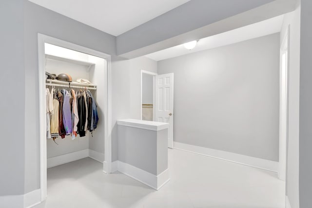 bathroom featuring baseboards and a walk in closet