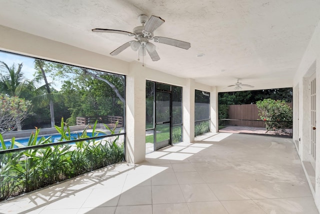 unfurnished sunroom featuring a ceiling fan