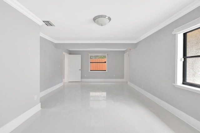 spare room with visible vents, baseboards, and ornamental molding