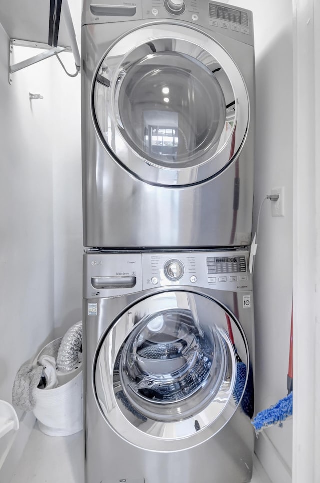 laundry room featuring stacked washer / drying machine and laundry area