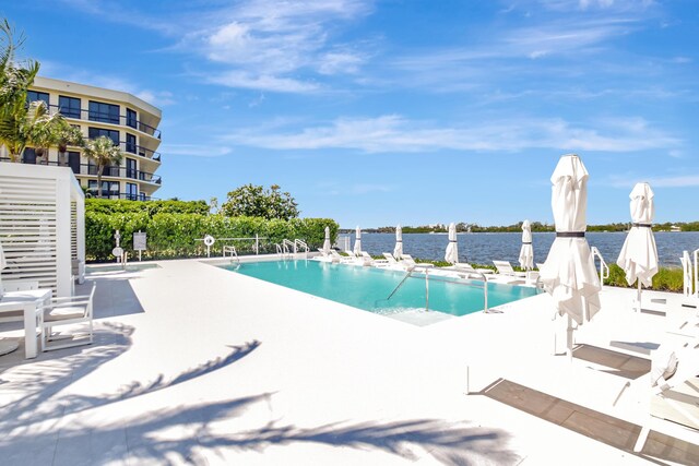 community pool with a patio area and a water view