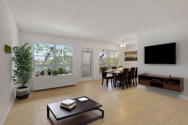 3034 Oakridge D 3034, Deerfield Beach, FL 33442 - living room featuring a textured ceiling, plenty of natural light, a ceiling fan, light tile patterned floors, and baseboards