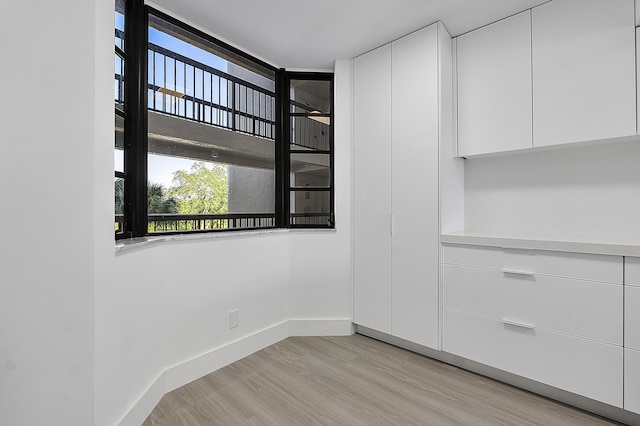 spare room featuring light wood-style flooring and baseboards