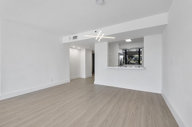 unfurnished living room with light wood-style floors, baseboards, and visible vents