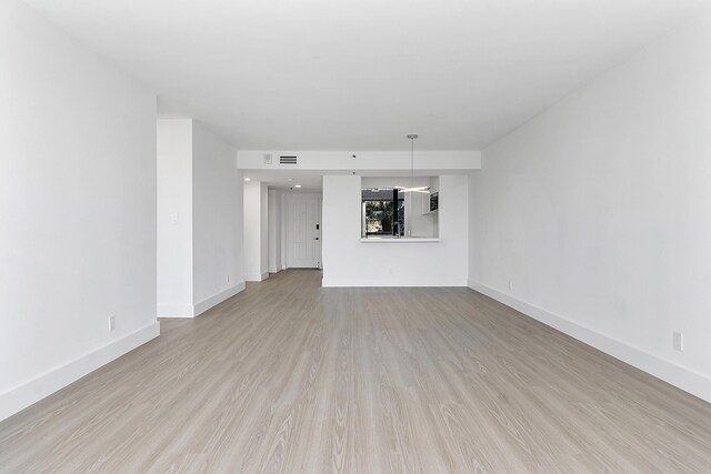 unfurnished living room with visible vents, baseboards, and light wood-style floors