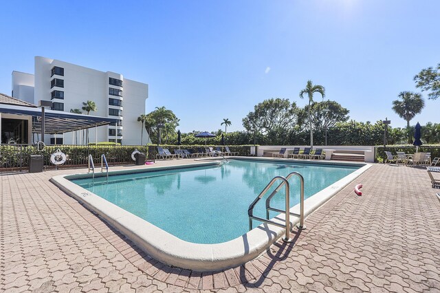 community pool with a patio and fence