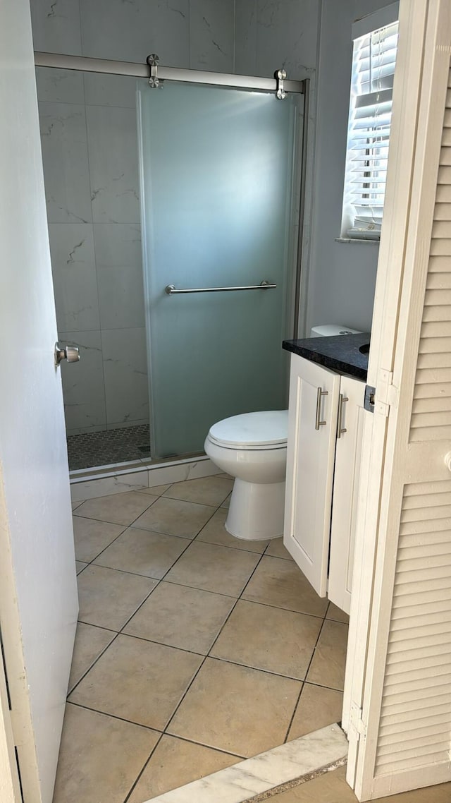 25 Crossings Cir Unit F, Boynton Beach, FL 33435 - bathroom featuring toilet, a stall shower, vanity, and tile patterned flooring