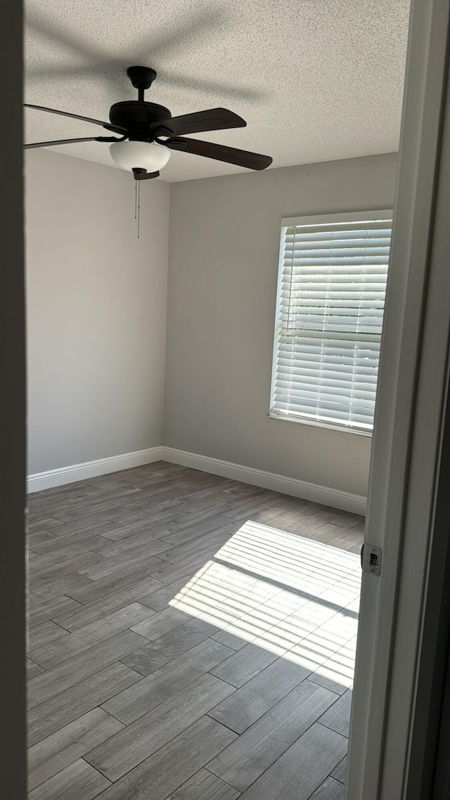 25 Crossings Cir Unit F, Boynton Beach, FL 33435 - empty room with a ceiling fan, wood finished floors, a textured ceiling, and baseboards