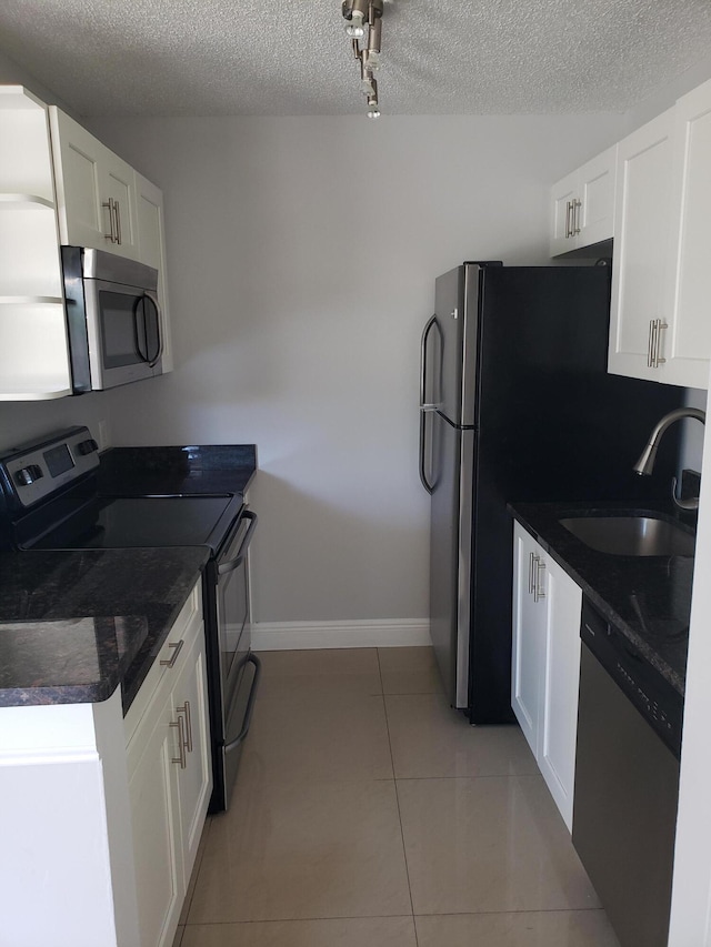 25 Crossings Cir Unit F, Boynton Beach, FL 33435 - kitchen featuring stainless steel appliances, a sink, a textured ceiling, dark countertops, and white cabinetry