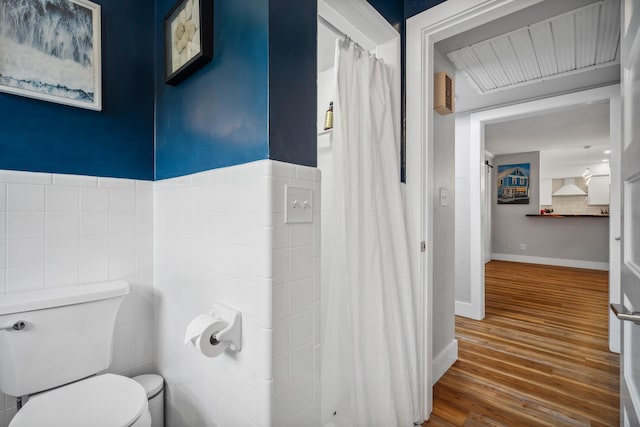 full bath with a shower with shower curtain, toilet, and wood finished floors