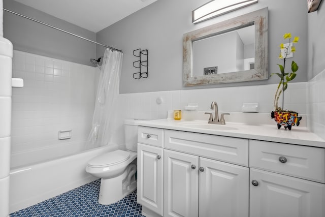 full bath featuring vanity, toilet, tile walls, a wainscoted wall, and shower / tub combo
