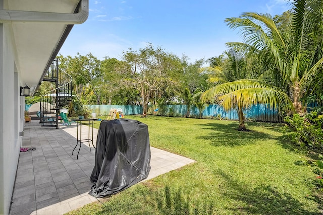 view of yard with a fenced backyard, stairs, and a patio area