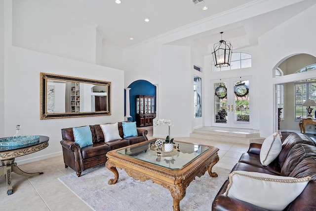 living area with ornamental molding, tile patterned floors, an inviting chandelier, and a high ceiling
