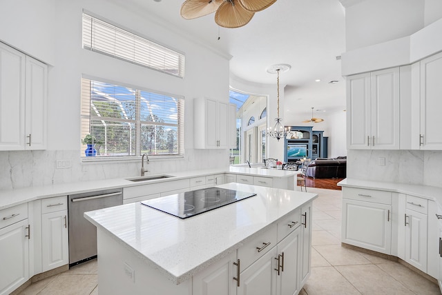 kitchen with a center island, black electric cooktop, dishwasher, a sink, and ceiling fan with notable chandelier