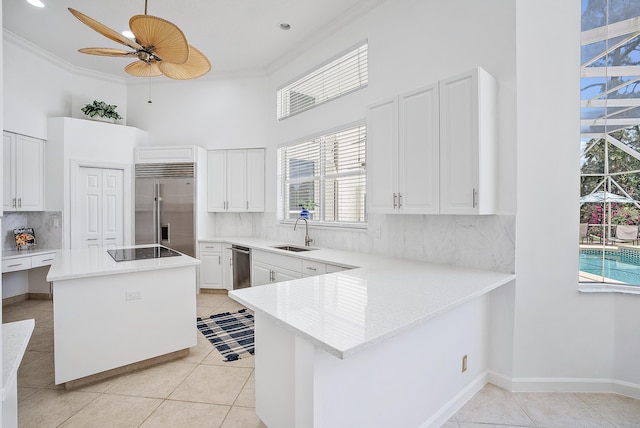 kitchen featuring a sink, ornamental molding, a ceiling fan, stainless steel appliances, and light tile patterned flooring